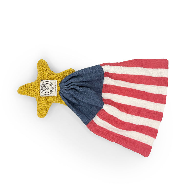 Reverse side of an American flag-inspired lovey blanket with a yellow crochet star and sewn label.