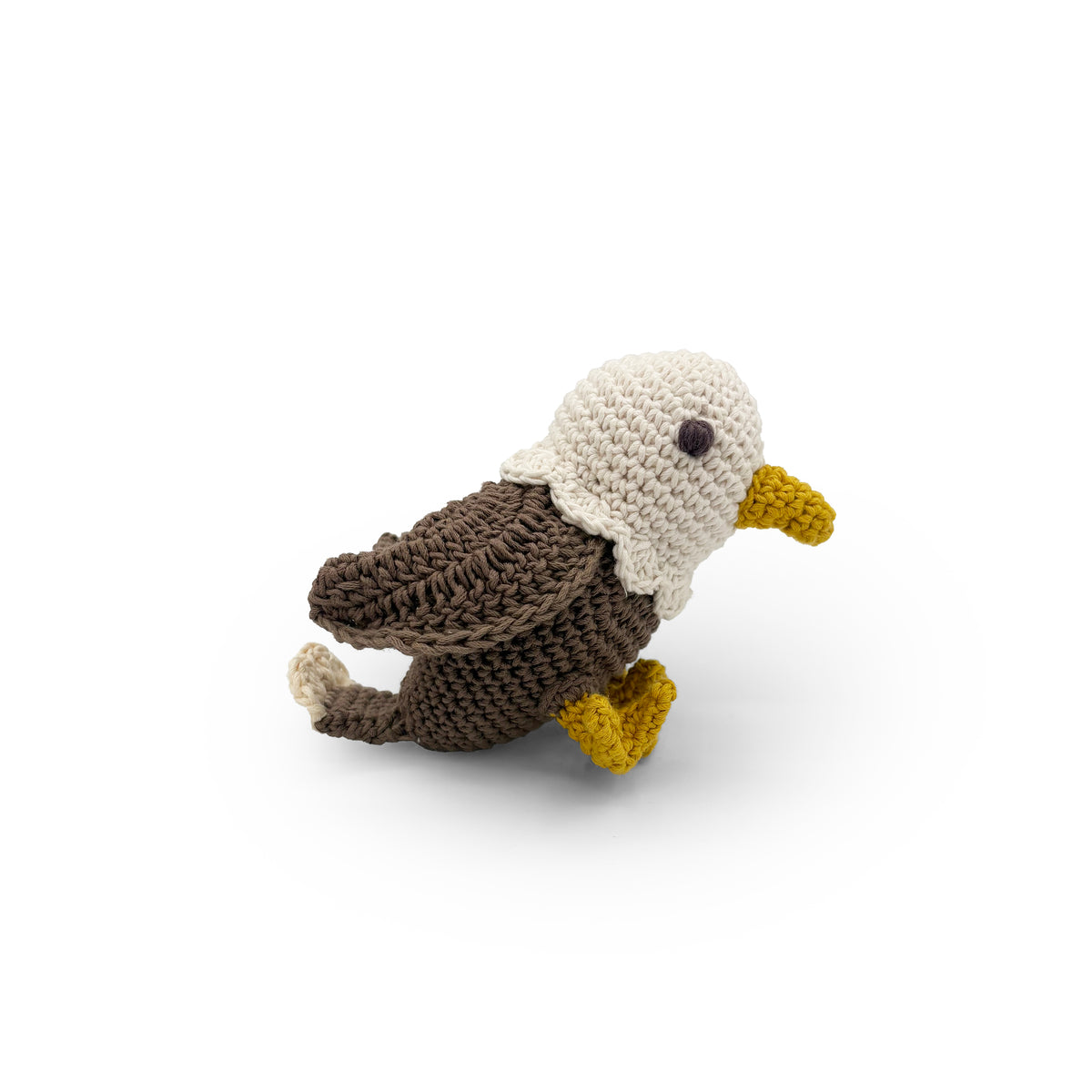 Crochet bald eagle in side view with a white head, brown wings and yellow beak and feet.