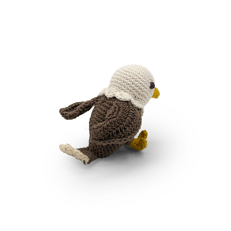 Crochet bald eagle in side view with a white head, brown wings and yellow beak and feet.